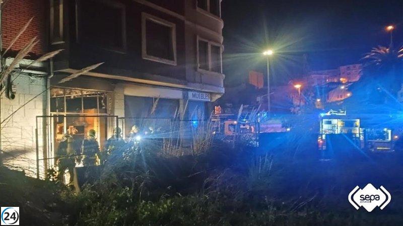 Los bomberos controlan el fuego en una mueblería deshabitada en Avilés.